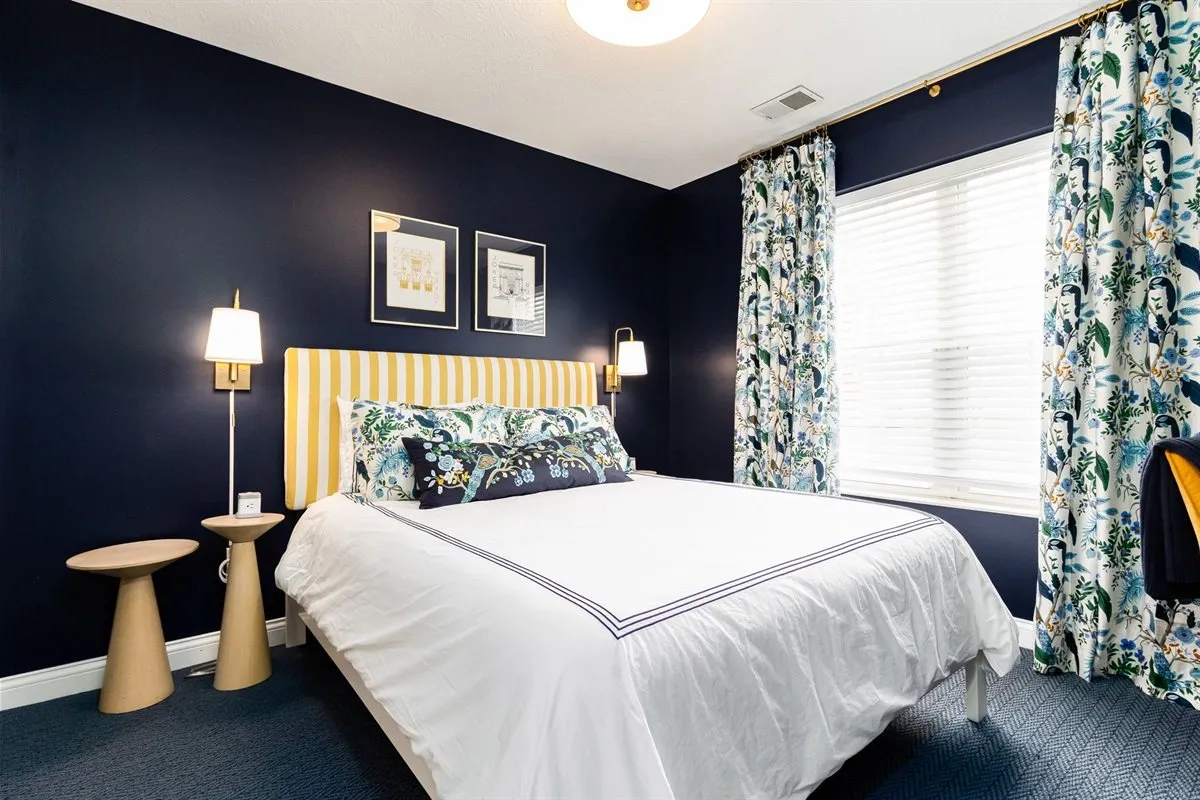 Guest bedroom with navy walls in a managed Airbnb near Notre Dame